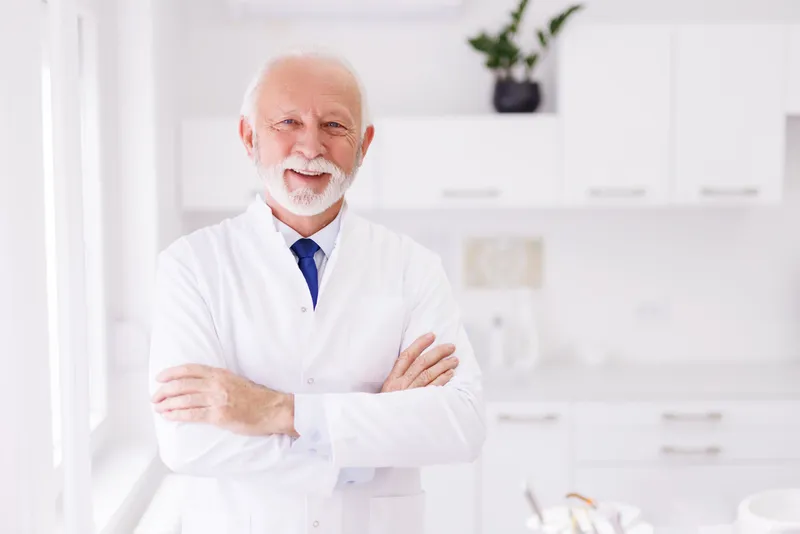 Senior dentist standing in his practice